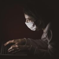 电脑之家内容运营何一舟在整理读者纠错邮件，屏幕上并列着几个来源页面与标注笔记，桌面整洁，氛围踏实